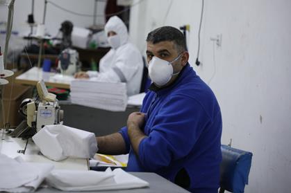 Des travailleurs palestiniens produisent des équipements de protection contre le COVID-19 dans un atelier de Naplouse