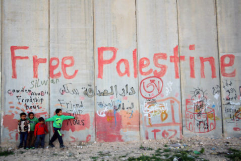 3 avril 2014. Des enfants palestiniens rassemblés au pied de la barrière israélienne de séparation, dans le village d’Abu Dis, à Jérusalem-Est. (Photo : Saeed Qaq/APA Images)