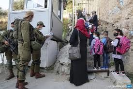 6 septembre 2020, à proximité de la colonie juive de Beit Hadasa, dans la ville de Hébron, en Cisjordanie occupée, des étudiants et des enseignants palestiniens attendent à un check-point militaire que les soldats israéliens les laissent passer pour qu'ils puissent se rendre à l'école en ce premier jour de classe. (Photo : AFP / Hazem Bader)