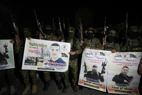 Le 2 avril 2022, des combattants palestiniens de Saraya al-Quds, l’aile militaire de l’organisation de résistance du Djihad islamique, participent à un défilé militaire à Khan Younis, dans le sud de la bande de Gaza. Ils brandissent des bannières portant les noms et les photos de leurs camarades tués récemment par les forces israéliennes. (Photo : Ashraf Amra APA images)