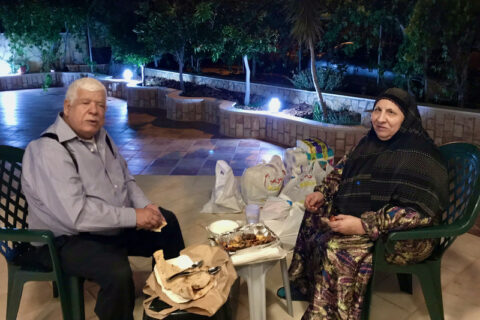 Une photo de famille de 2019 montre le grand-père palestino-américain Omar Assad, à gauche, et sa femme Nazmieh partageant un repas dans le patio de leur maison à Jiljilya, en Cisjordanie occupée. (Photo : avec l’aimable autorisation de la famille)