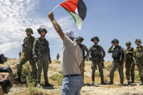 20 mai 2022. Al-Tuwani, village des collines du sud de Hébron, en Cisjordanie. Un manifestant brandit un drapeau palestinien lors d’une manifestation de solidarité avec Masafer Yatta. (Photo : Heather Sharona Weiss / ActiveStills)