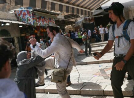 Un colon israélien brutalise une Palestinienne tandis que l’autre, à droite de la photo, se prépare à l’asperger de gaz au poivre, lors de la « marche des drapeaux », le 29 mai 2022, à Jérusalem-est.