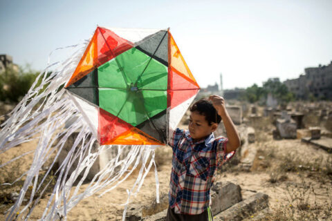 Un enfant joue avec un cerf-volant dans le cimetière du camp de réfugiés de Jabaliya, dans la bande de Gaza, le 8 juin. Il y a environ 110 000 réfugiés vivant dans le camp de Jabaliya, qui couvre une superficie de seulement 1,4 kilomètre carré selon l’UNRWA, l’agence des Nations Unies pour les réfugiés de Palestine – Photo : Anne Paq/ActiveStills.org