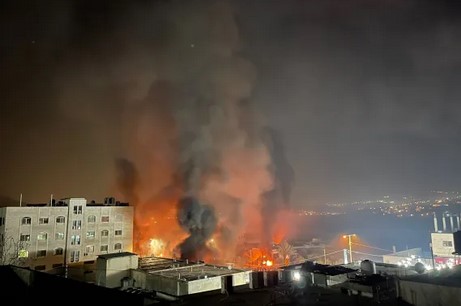 27 février 2023. Des flammes et de la fumée s’élèvent de la ville de Huwara, en Cisjordanie, suite à sa mise à sac par des colons israéliens