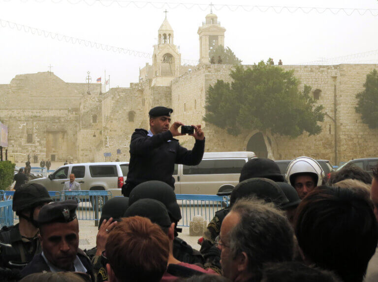 Un garde de l’Autorité palestinienne photographie des protestataires lors de la visite à Bethléem du président américain Obama, en 2013. Deux rangées de membres des forces sécuritaires garantissent que personne n’ira plus loin. (Photo : Tom Suárez)