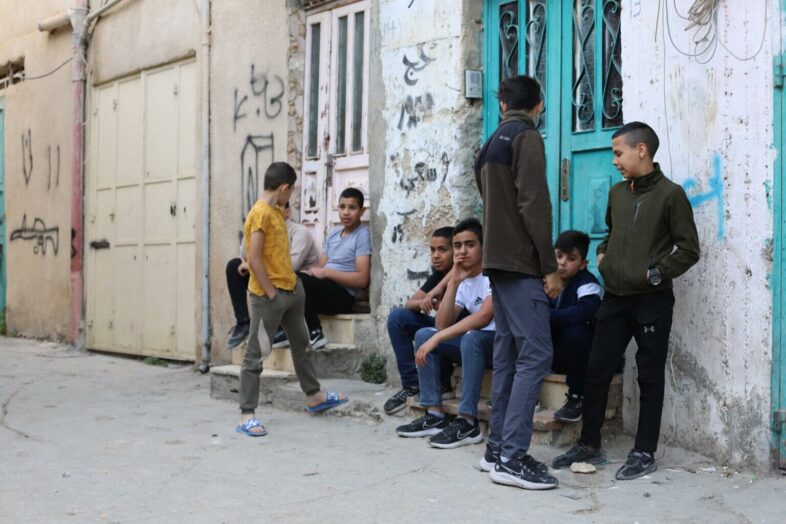 Un groupe de garçons traîne dans une rue. (Photo : Malik Hamamra / Mondoweiss) Camp de réfugiés d’Aida, Cisjordanie occupée, mai 2023. 