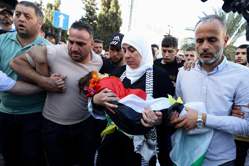 La gouverneure de Ramallah, Laila Ghannam, tient dans ses bras le corps de l'enfant Muhammad Tamimi, , décédé le 5 juin après avoir été touché à la tête par une balle israélienne, la semaine dernière, à Ramallah, en Cisjordanie. (Photo : Ahmad Arouri / APA images)