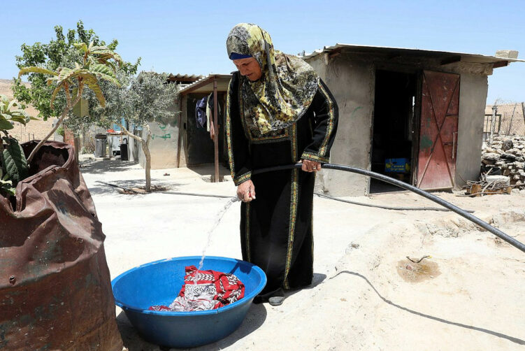 10 mai 2022. Une Palestinienne se sert d’un tuyau à eau à Masafer Yatta, en Cisjordanie.