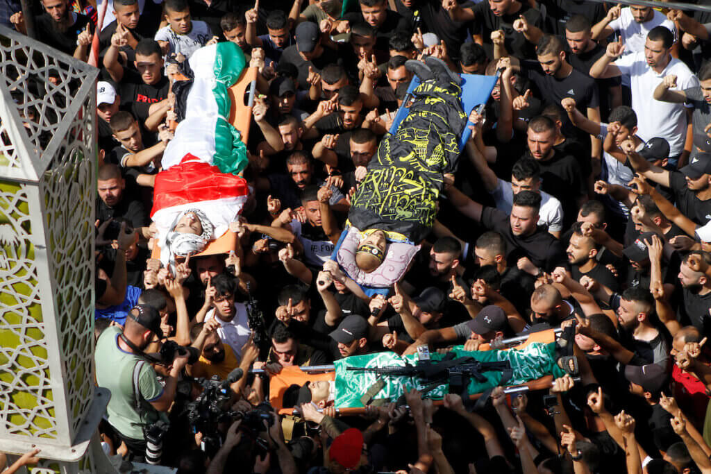 Des gens endeuillés portent les corps de trois combattants de la résistance palestinienne, Rafat Khamayseh, Mahmoud al-Sa’di et Mahmoud Ararawi, tués au cours d’un raid israélien contre le camp de réfugiés de Jénine, le 20 septembre 2023
