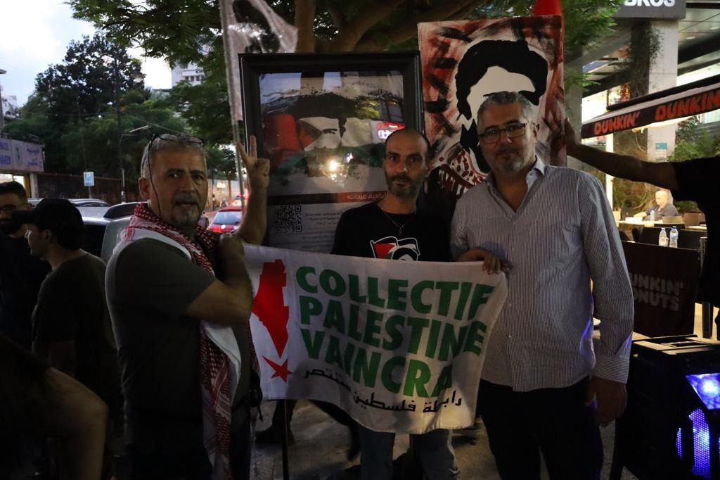 Le résistant et ancien prisonnier politique Anwar Yassin (à gauche) et des membres de la Campagne libanaise pour la libération de Georges Abdallah se sont pris en photo en déployant un drapeau du Collectif Palestine Vaincra.