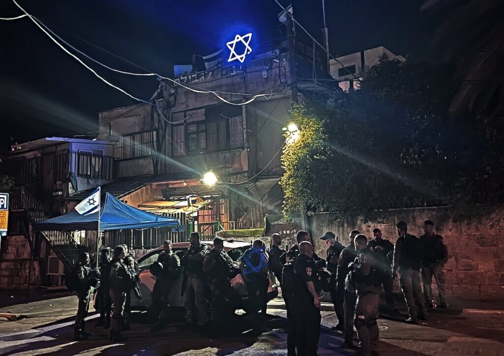 Sheikh Jarrah. Des hommes des forces d’occupation israéliennes sont positionnés en face de la maison familiale des Ghawi, dont des colons israéliens se sont emparés en 2009 et au sommet de laquelle on a placé une étoile de David de néon. La photo a été prise en mai 2021. (Photo : Mohammed El-Kurd)