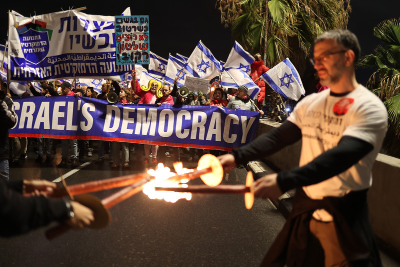 Israël, Tel-Aviv. Des Israéliens brandissent des banderoles et des écriteaux au cours d’une manifestation contre les propositions de réformes judiciaires. 