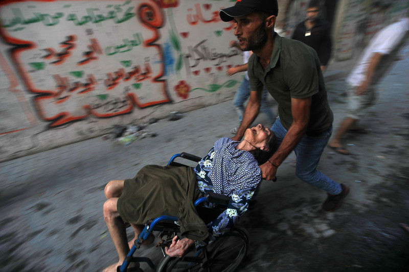 11 octobre 2023, Gaza. Une femme âgée est évacuée suite à une frappe aérienne