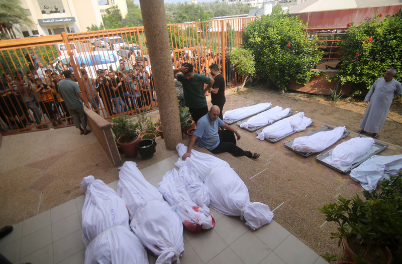 11 octobre 2023. Des Palestiniens sont rassemblés dans la cour d’une morgueoù ont été déposés les corps enveloppés des Palestiniens tués lors d’une frappe aérienne d’Israël à Khan Younis, dans le sud de la bande de Gaza. 