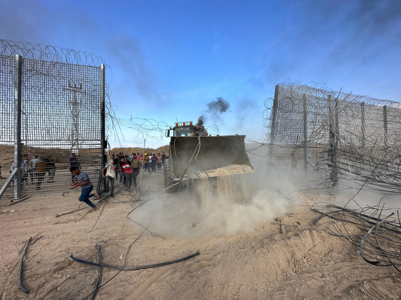 Gaza, 7 octobre 2023. Des Palestiniens détruisent une partie de la clôture militarisée d’Israël le long de la frontière est de Gaza