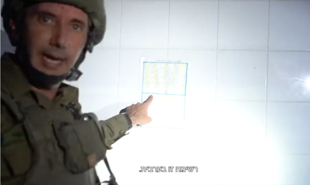 Dans un arrêt sur vidéo, le porte-parole de l’armée israélienne, Daniel Hagari, ponte le doigt sur un calendrier mural dont il prétend qu’il s’agit d’une liste de noms de « terroristes ».