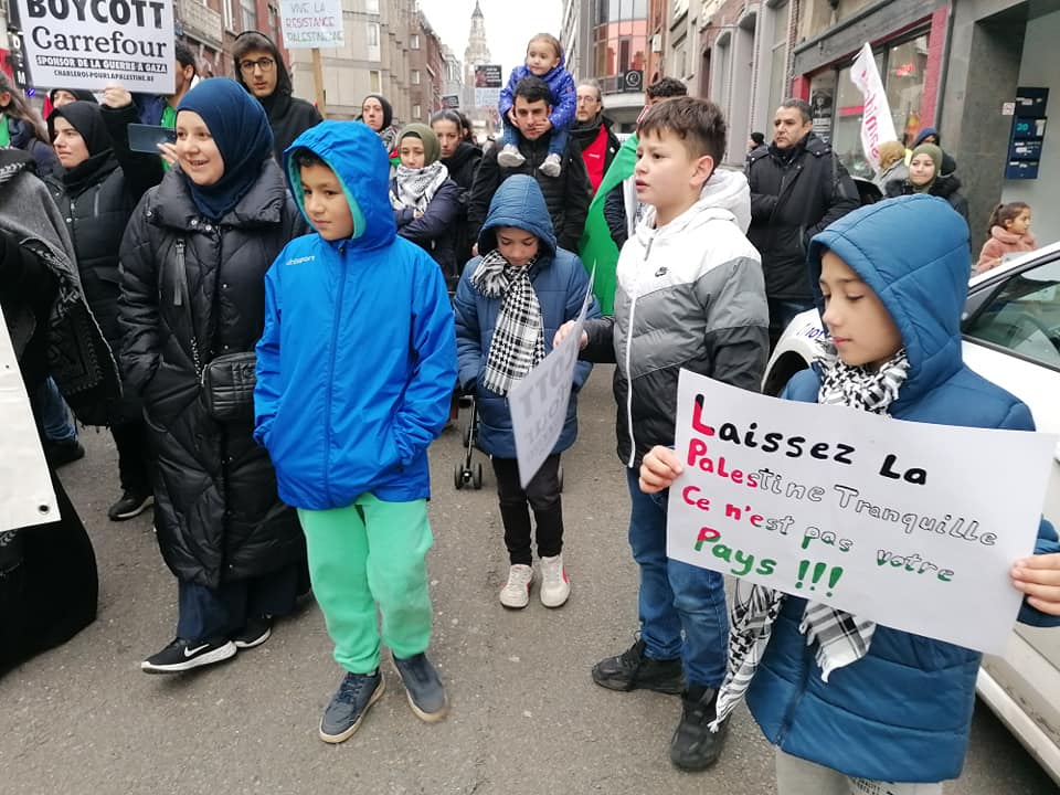 Manifestation "Stop au génocide du peuple palestinien". Charleroi, 16 décembre 2023. Un enfant porte un panneau : "Laissez la Palestine tranquille, ce n'est pas votre pays.