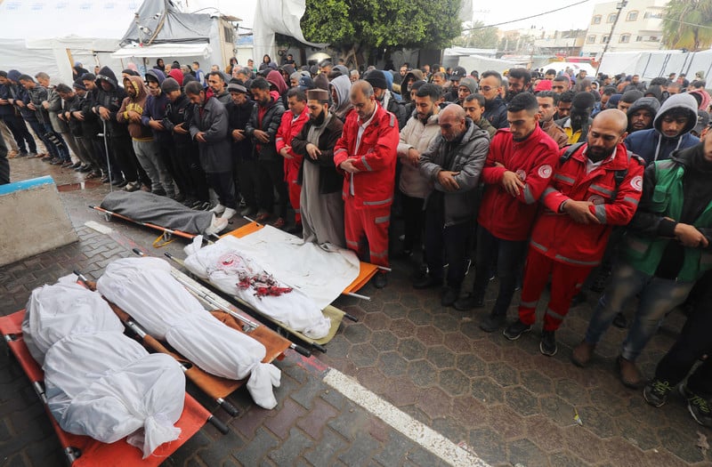 Le personnel de la Société du Croissant-Rouge de Palestine (SCRP) organise les funérailles de quatre membres de son équipe de paramédicaux tués par une frappe aérienne ciblée d’Israël contre une ambulance à Deir al-Balah, le 11 janvier 2024. 