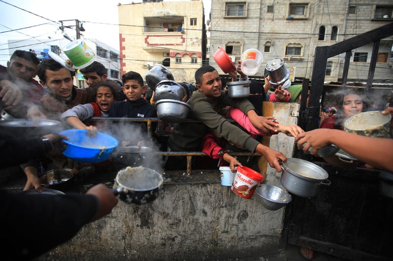 23 décembre 2023. Des Palestiniens font la file pour un repas préparé par des volontaires à Raha, dans le sud de Gaza. 