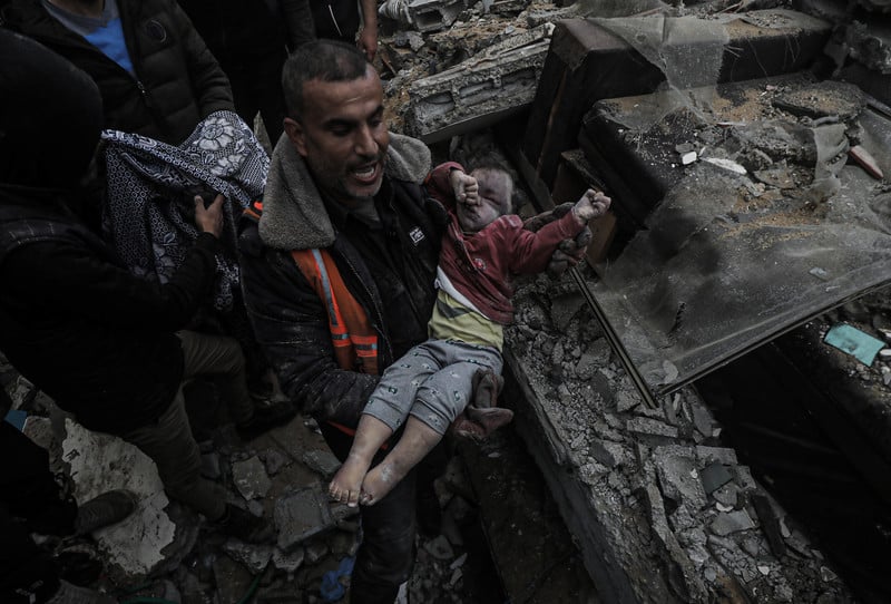 L'agenda de changement de régime de Biden prolonge le génocide de Gaza. Photo : 7 mars 2024. Des Palestiniens retrouvent le corps d'un enfant dans les décombres de sa maison, suite à une frappe aérienne israélienne à Deir al-Balah, dans la partie centrale de Gaza.