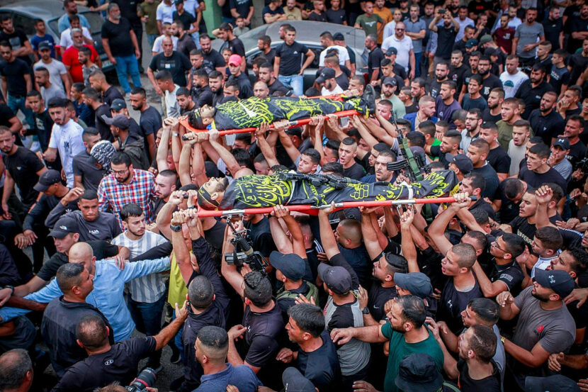 Des Palestiniens en deuil et des hommes armés assistent aux funérailles de deux Palestiniens qui ont été tués lors d'une frappe aérienne israélienne à Jénine, dans le nord de la Cisjordanie occupée, le 27 octobre 2023.
