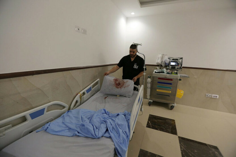 Un infirmier palestinien se tient à côté d'un lit d'hôpital et d'un oreiller couvert de sang après une opération militaire israélienne à l'hôpital Ibn Sina, dans la ville de Jénine en Cisjordanie occupée, le 30 janvier 2024. (Nasser Ishtayeh/Flash90)