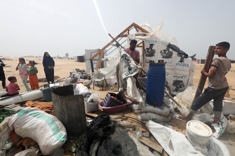 L'aide s'est raréfiée depuis qu'Israël a pris le contrôle de la frontière sud de Gaza. Photo : 27 mai 2024. Des Palestiniens déplacés démontent leur tente afin de fuir vers des zones plus sûres, après qu'Israël a attaqué un campement situé à proximité des entrepôts de l'UNRWA à Rafah, dans le sud de Gaza. 