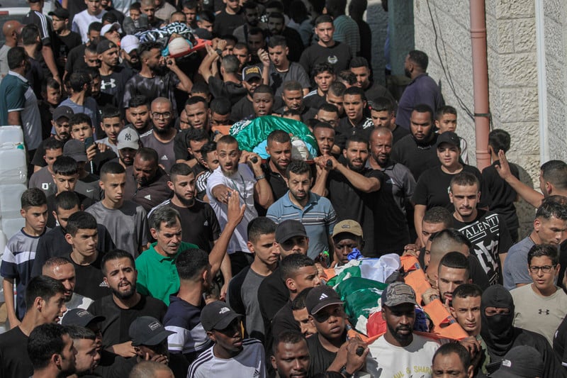 4 octobre 2024. Des personnes endeuillées assistent aux funérailles de Palestiniens tués le soir précédent lors d'une frappe de l'aviation israélienne sur le camp de réfugiés de Tulkarem, en Cisjordanie occupée. 