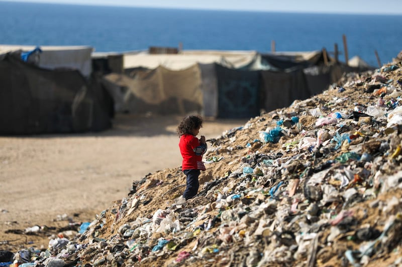 14 novembre 2024. Une petite Palestinienne récupère certains déchets dans l'espoir de les revendre dans le camp de réfugiés de Nuseirat, au centre de la bande de Gaza. 