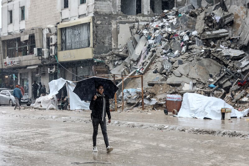 Israël torture le Dr Hussam Abu Safiya et prolonge sa détention arbitraire. Photo : Ce 12 février 2025, dans le quartier d'al-Rimal (centre-ville de Gaza), un jeune Palestinien longe un amas de décombres sous des conditions météorologiques épouvantables