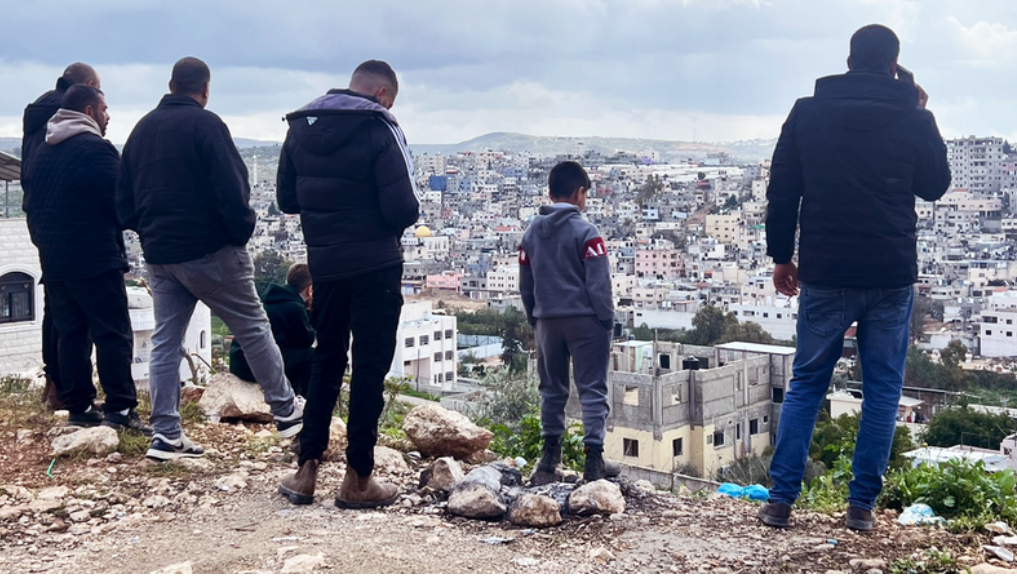 Les soldats israéliens vandalisent et profanent des maisons en Cisjordanie. Photo : Des gens se rassemblent au sommet d'une colline afin de voir ce qu'il advient de leurs maisons dans le camp de réfugiés de Nur Shams, près de Tulkarem. (Photo : Zena Al Tahhan)