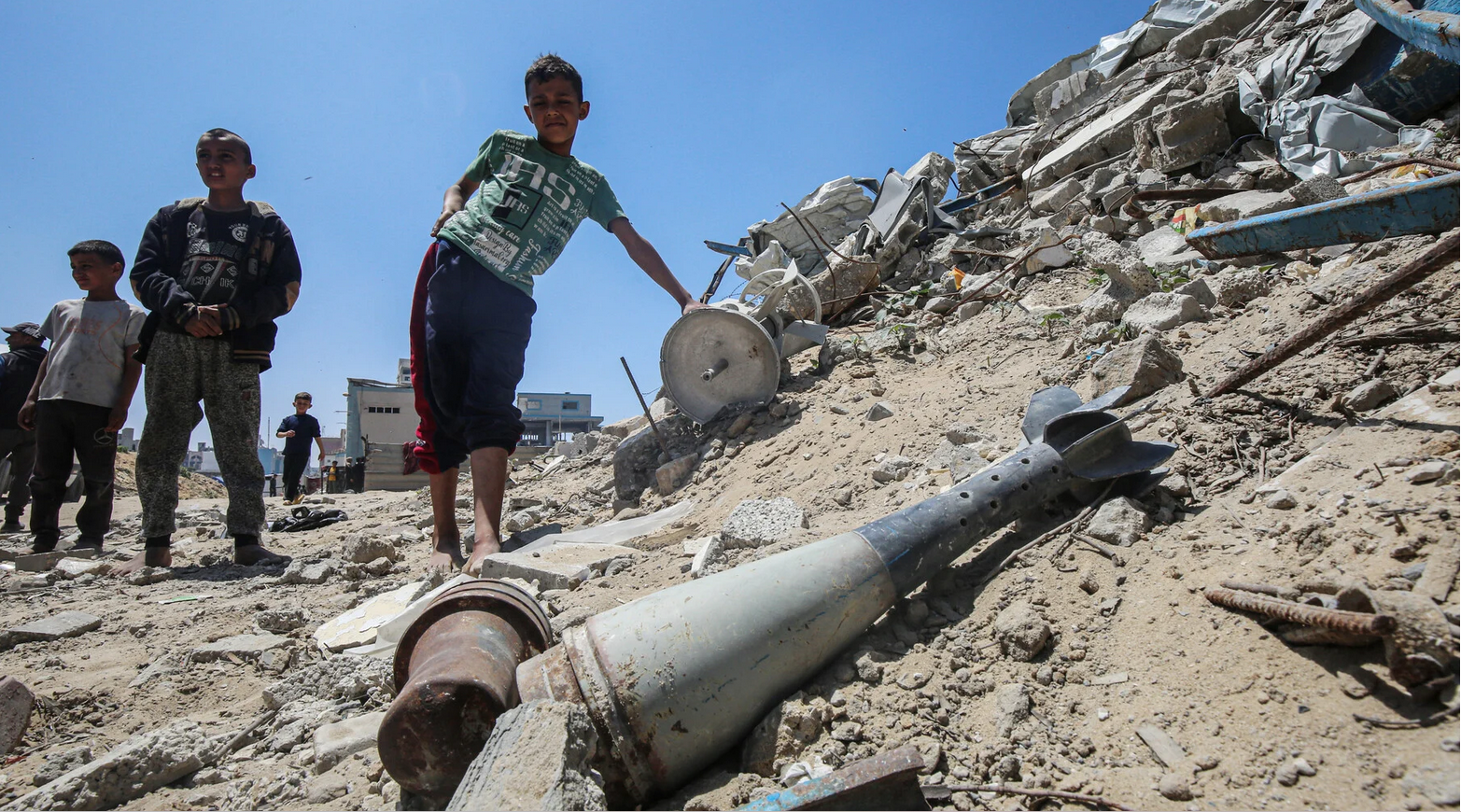 20 avril. Des enfants se rassemblent à proximité de débris militaires dans la zone de Jawazat, qui a servi de QG à la police palestinienne, à l'ouest de la ville de Gaza.