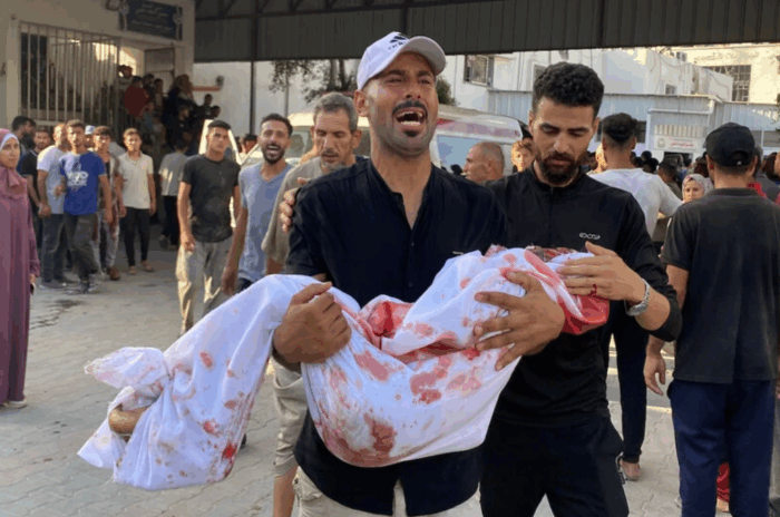 Des gens éplorés portent les corps d'enfants palestiniens qui viennent de perdre la vie lors d'une frappe de l'aviation israélienne sur le camp de réfugiés de Beach, à Gaza, le 12 juillet.