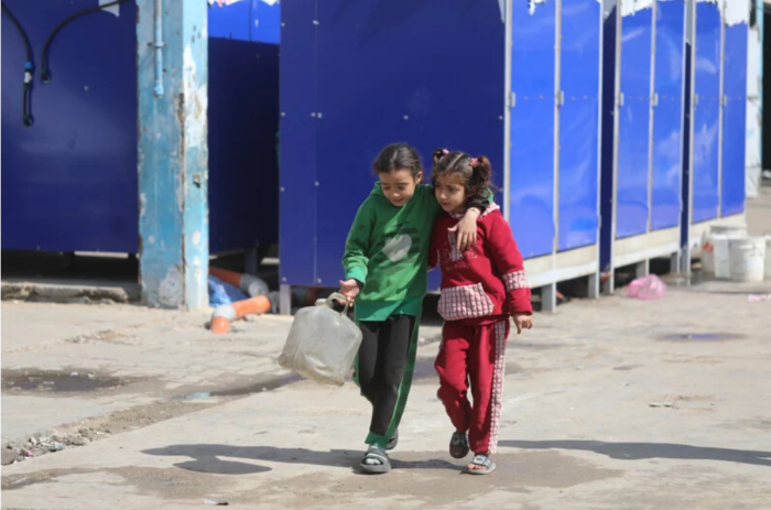 11 mars 2026. Vivant sous blocus permanent, les Palestiniens déplacés tentent de subvenir à leurs besoins quotidiens en eau en remplissant des récipients dans un refuge à Gaza. 