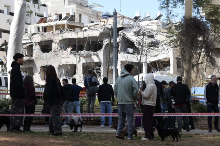 L'Iran riposte. Photo : 1er mars 2026. Des gens examinent les dégâts à Tel-Aviv après que des missiles balistiques iraniens, lancés en guise de représailles contre les frappes coordonnées américano-israéliennes, ont touché certaines parties de la ville. 