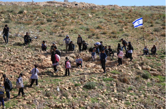13 avril 2026. Des colons israéliens installent des barbelés et des drapeaux et bloquent le passage des enseignants et étudiants palestiniens qui se rendent à leur école, à Umm al-Khair, un hameau de Masafar Yatta, en Cisjordanie occupée. (Photo : Mosab Shawer / ActiveStills)