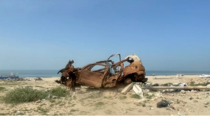 Lorsque l'armée israélienne s'est mise à tirer sur les demandeurs d'aide, les gens se sont cachés derrière tout ce qu'ils pouvaient trouver à proximité, y compris des voitures comme celle-ci, tout près du tond-point d'al-Nabulsi, près de Gaza (Photo prise en février 2006). (Photo : Khaled Al-Qershali / The Electronic Intifada)