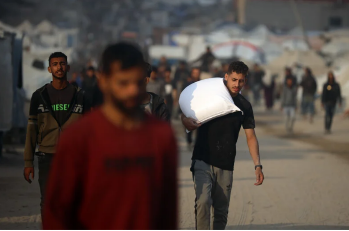 Des gens emportent les sacs de farine qu'ils ont reçus des camions humanitaires à Gaza (10 juin 2026). (Photo : Omar Ashtawy / APA images)